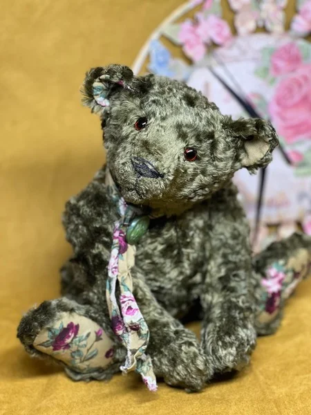 Collectible green teddy bear with roses on the heels